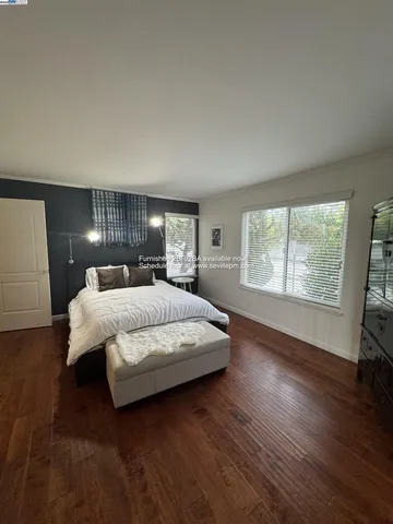 a large bed sitting in a bedroom next to a window