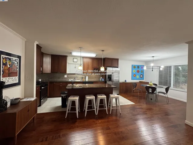 a dining room with furniture wooden floor a rug a fireplace and a painting