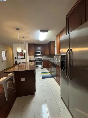 a kitchen with granite countertop stainless steel appliances and a refrigerator
