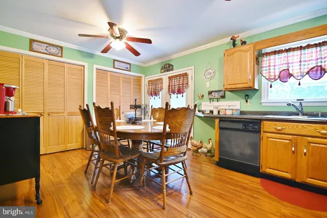 a kitchen with stainless steel appliances granite countertop wooden floor dining table and chairs