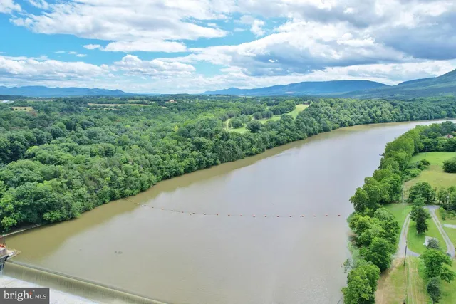 a view of a green field with wooden fence
