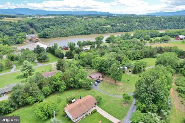 an aerial view of a house with a yard and lake view