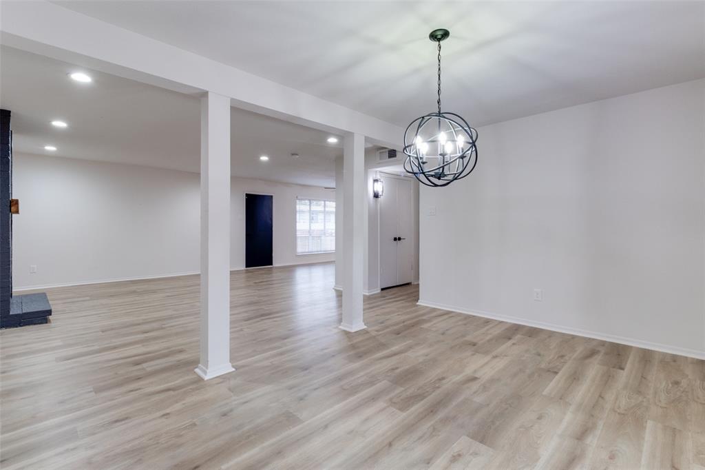 10530 Stone Canyon Road, Unit 208 Dallas, TX 75230 - Photo 16 of 24 a view of a hallway with wooden floor and chandelier