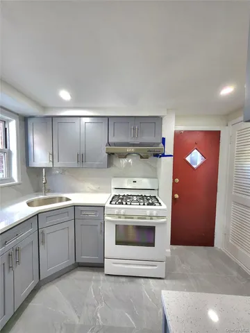 a kitchen with a stove and white cabinets