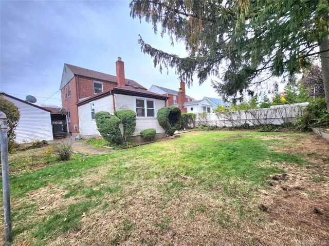 a view of a house with a yard and pathway