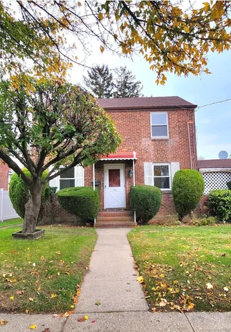 a front view of a house with yard and green space