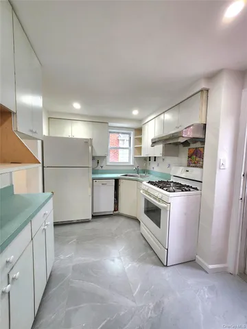 a kitchen with stainless steel appliances granite countertop a refrigerator sink and stove