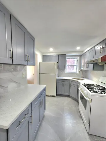 a kitchen with white cabinets and white appliances
