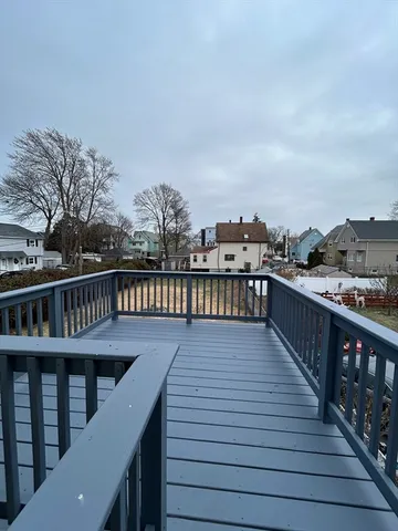 a view of a roof deck with two couches and wooden floor
