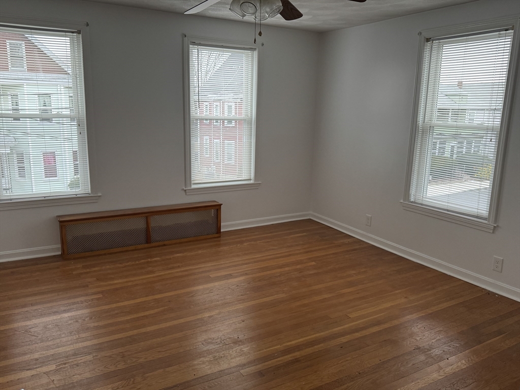 45 Highland Avenue, Unit 2 Everett, MA 02149 - Photo 4 of 9 an empty room with wooden floor and windows