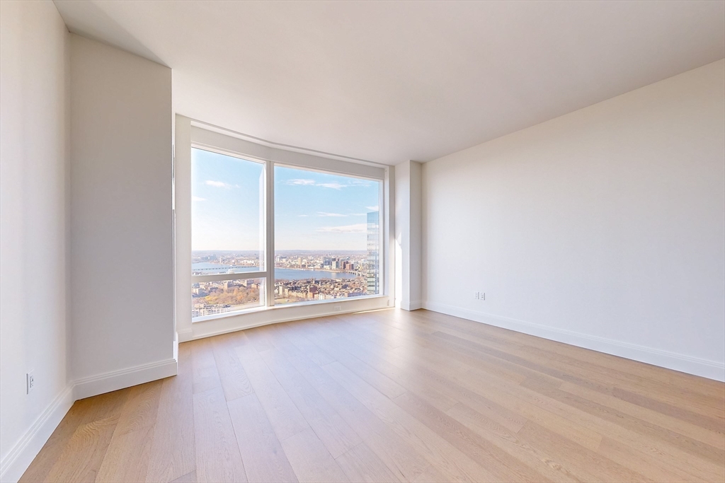 240 Devonshire Street, Unit U5401 Boston, MA 02110 - Photo 6 of 41 an empty room with wooden floor and windows