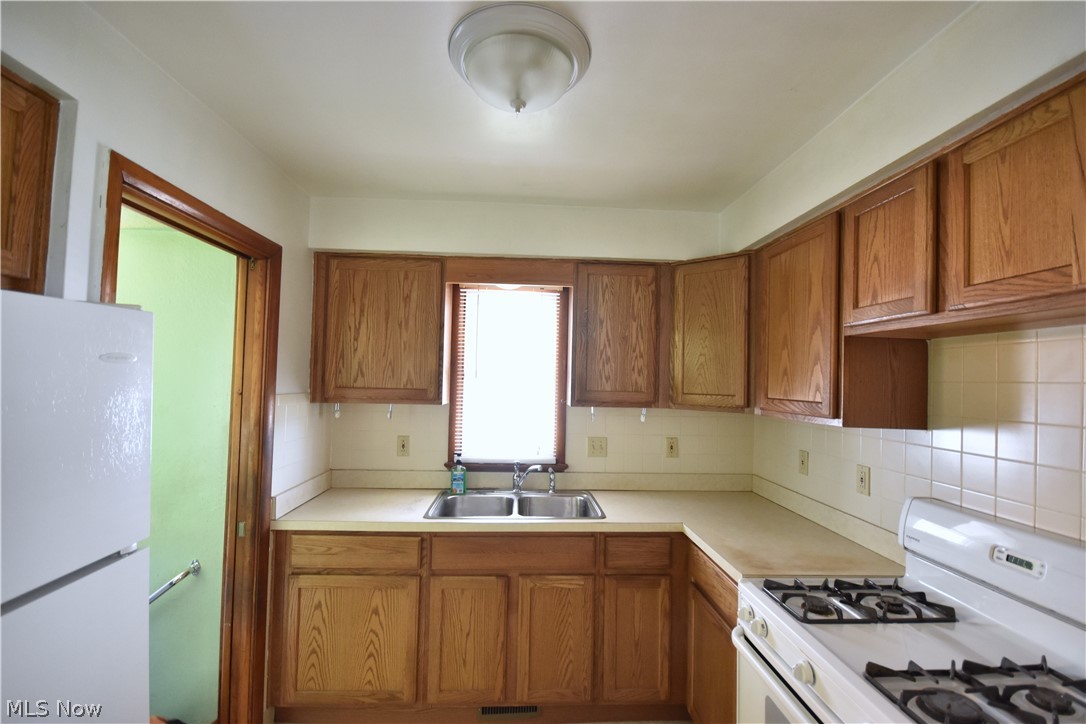 31921 Pendley Road Willowick, OH 44095 - Photo 6 of 22 Kitchen featuring sink, tasteful backsplash, and white appliances