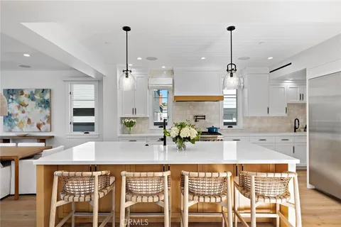 a kitchen with a table chairs sink and cabinets