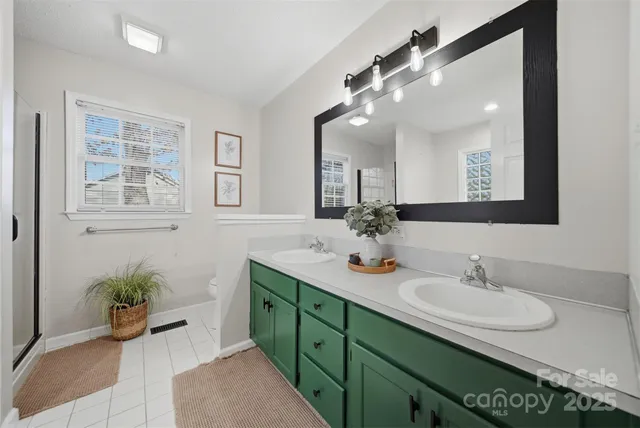 a bathroom with a granite countertop sink a large mirror and a shower