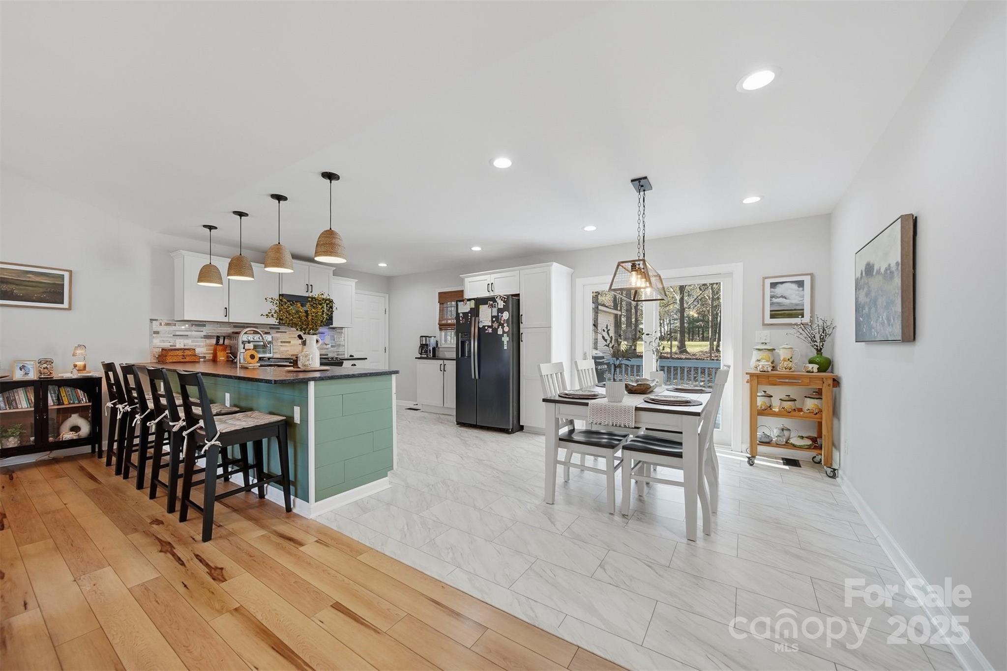 4687 Ransom Drive Conover, NC 28613 - Photo 10 of 27 a kitchen with stainless steel appliances kitchen island granite countertop a refrigerator a stove a dining table and chairs with wooden floor