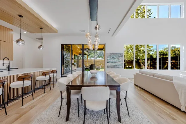 a dining hall with stainless steel appliances kitchen island a table and chairs