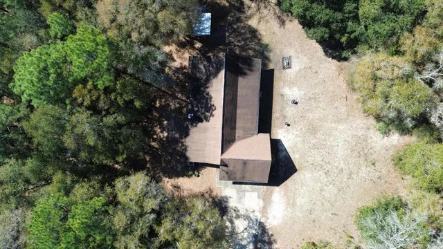 a vase of flowers sitting on a floor in front of yard
