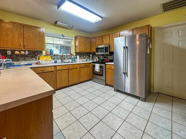 a kitchen with stainless steel appliances granite countertop a refrigerator sink and cabinets