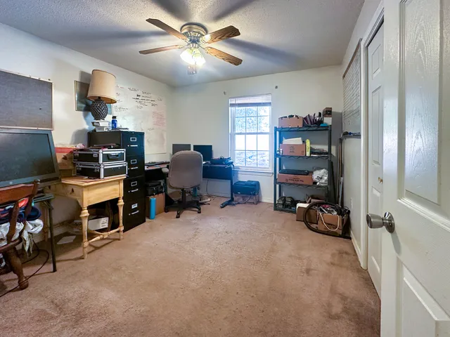 a view of a workspace with furniture and a window