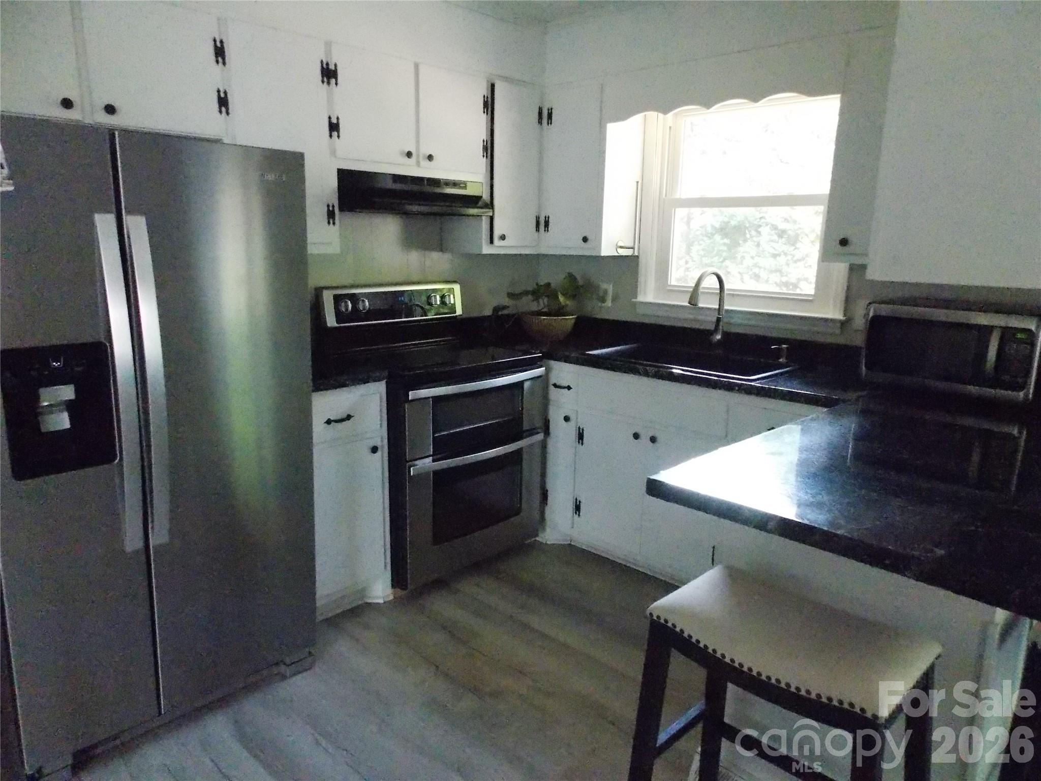 1380 May Road Granite Falls, NC 28630 - Photo 4 of 26 a kitchen with granite countertop a refrigerator stove and sink
