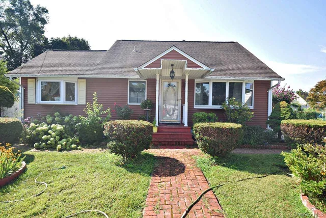 a front view of a house with a yard and garden