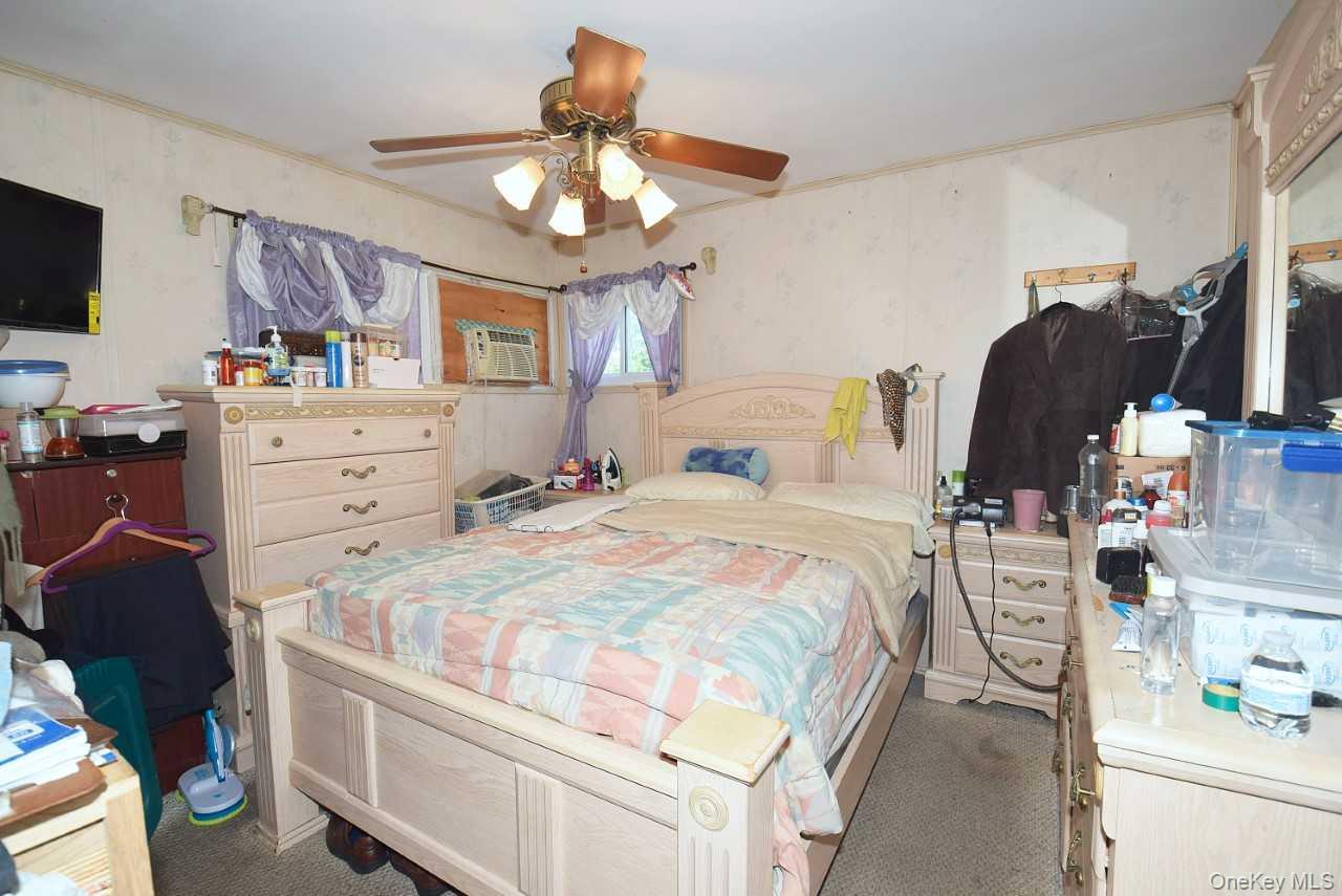 14 East Walnut Street Central Islip, NY 11722 - Photo 11 of 18 a bedroom with a bed and a chandelier