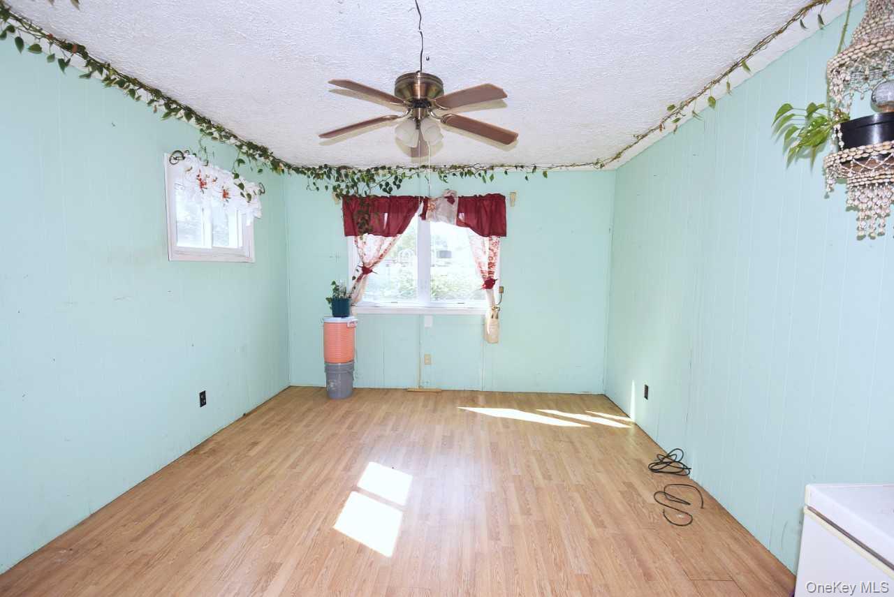 14 East Walnut Street Central Islip, NY 11722 - Photo 8 of 18 a view of a room with wooden floor ceiling fan and windows