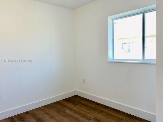 a view of a small space with wooden floor and a window