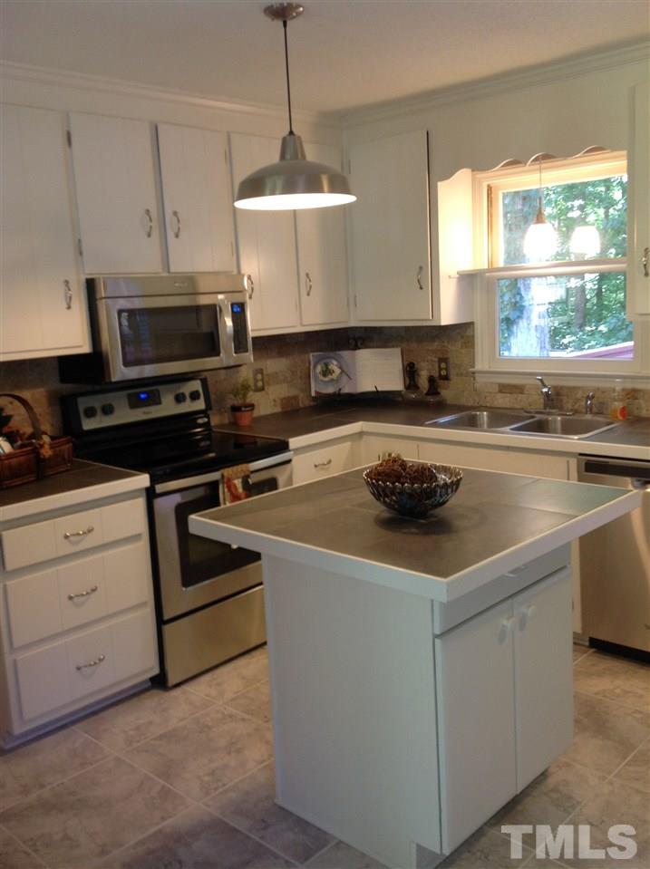 A kitchen that a cook will enjoy that has a nice kitchen eating area, and view into the living room