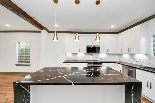 a kitchen with kitchen island a sink stainless steel appliances and cabinets
