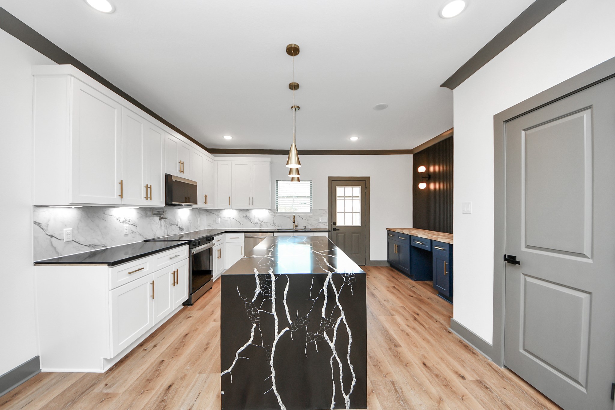 7925 Ritz Street, Unit A Houston, TX 77028 - Photo 14 of 35 a kitchen with stainless steel appliances granite countertop a stove top oven a sink dishwasher a dining table and chairs with wooden floor