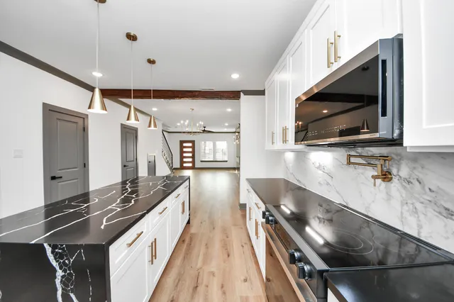 a kitchen with kitchen island granite countertop a sink stainless steel appliances and counter space
