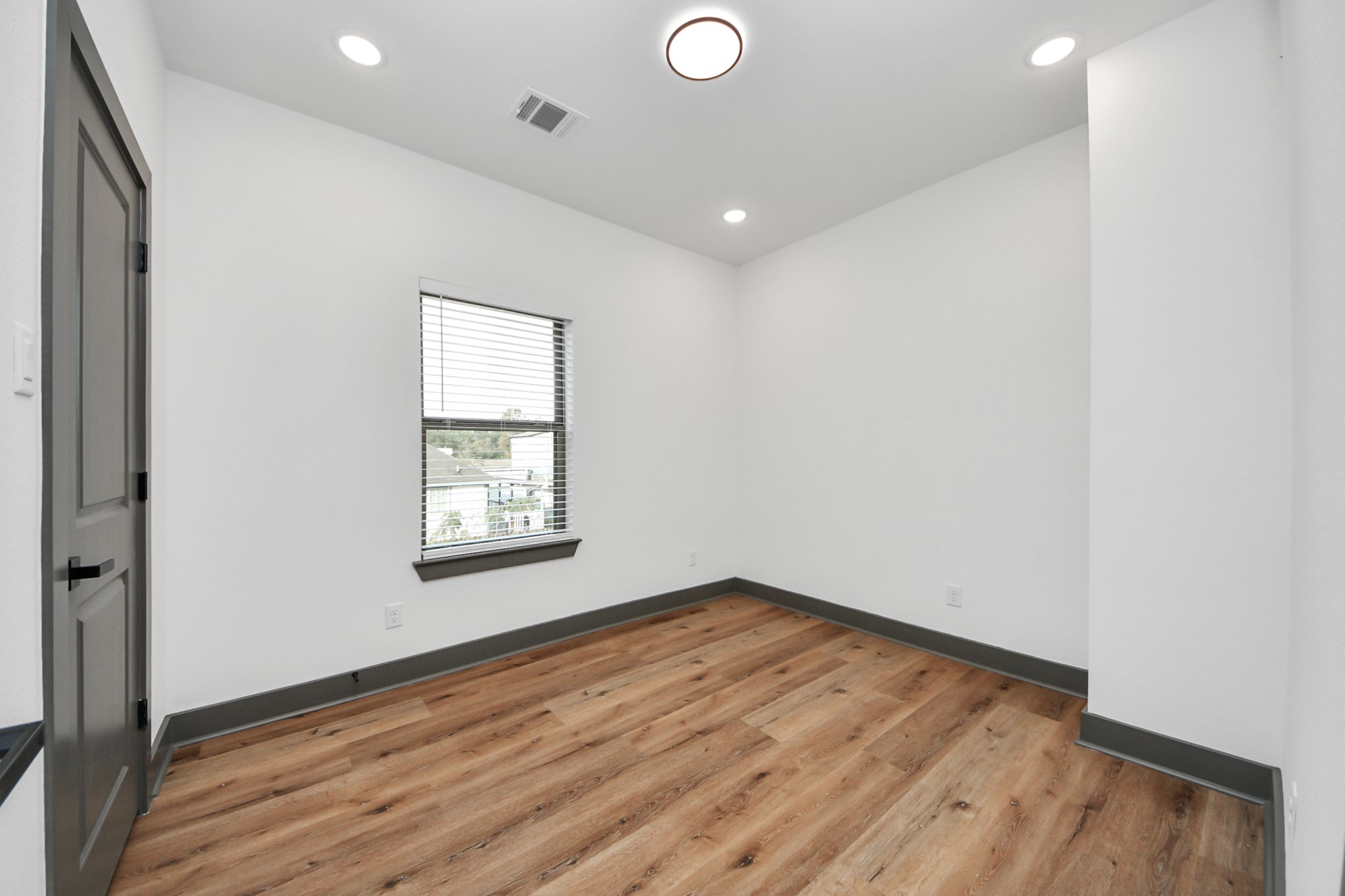 7925 Ritz Street, Unit A Houston, TX 77028 - Photo 25 of 35 an empty room with wooden floor and windows