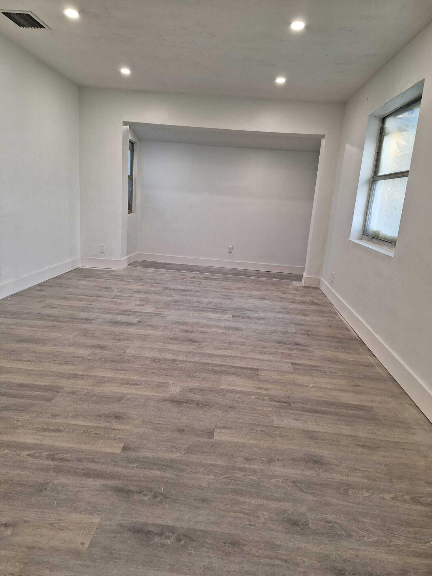 1000 West 1st Street Riviera Beach, FL 33404 - Photo 4 of 8 an empty room with wooden floor and windows