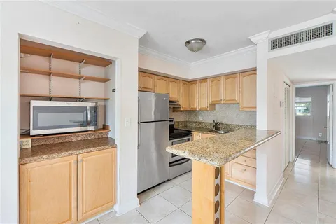 a kitchen with a refrigerator sink and cabinets