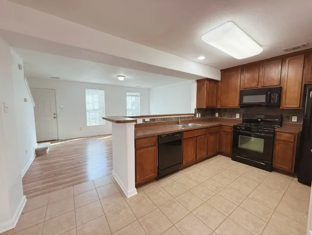 a kitchen with stainless steel appliances granite countertop a stove cabinets and a refrigerator
