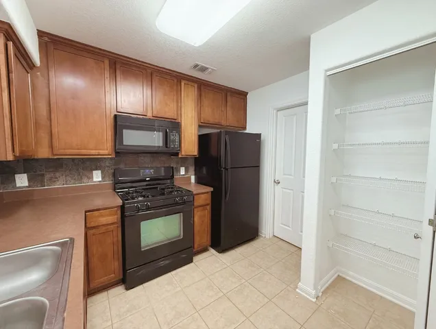 a kitchen with stainless steel appliances granite countertop a refrigerator stove and sink