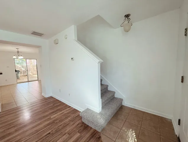a view of a hallway with wooden floor and closet