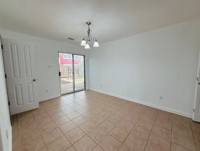 an empty room with windows and chandelier