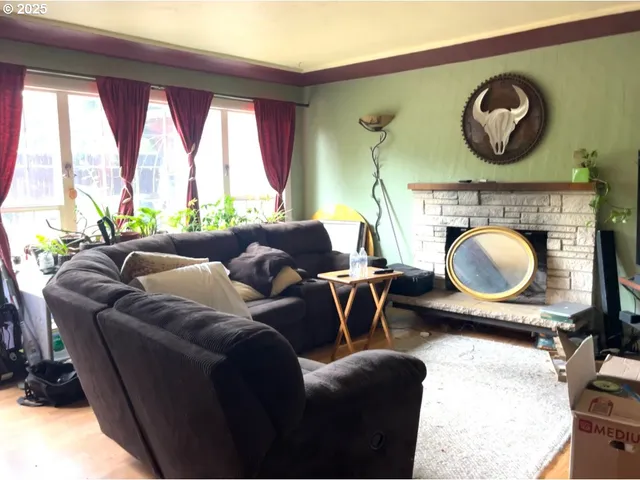 a living room with furniture a fireplace and a large window