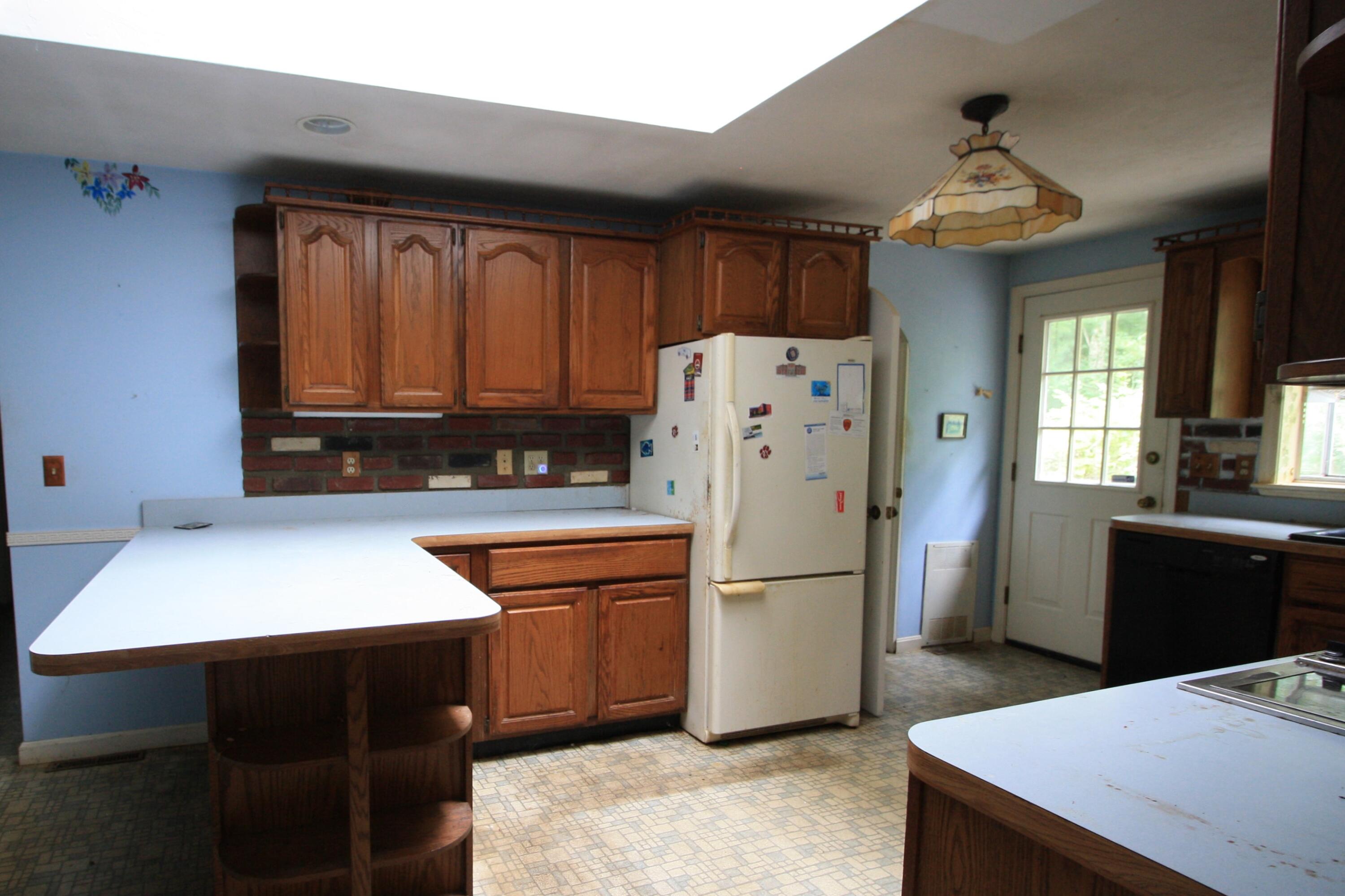 177 Thistle Drive Centerville, MA 02632 - Photo 11 of 22 a kitchen with stainless steel appliances granite countertop a refrigerator a sink dishwasher and a stove with wooden cabinets