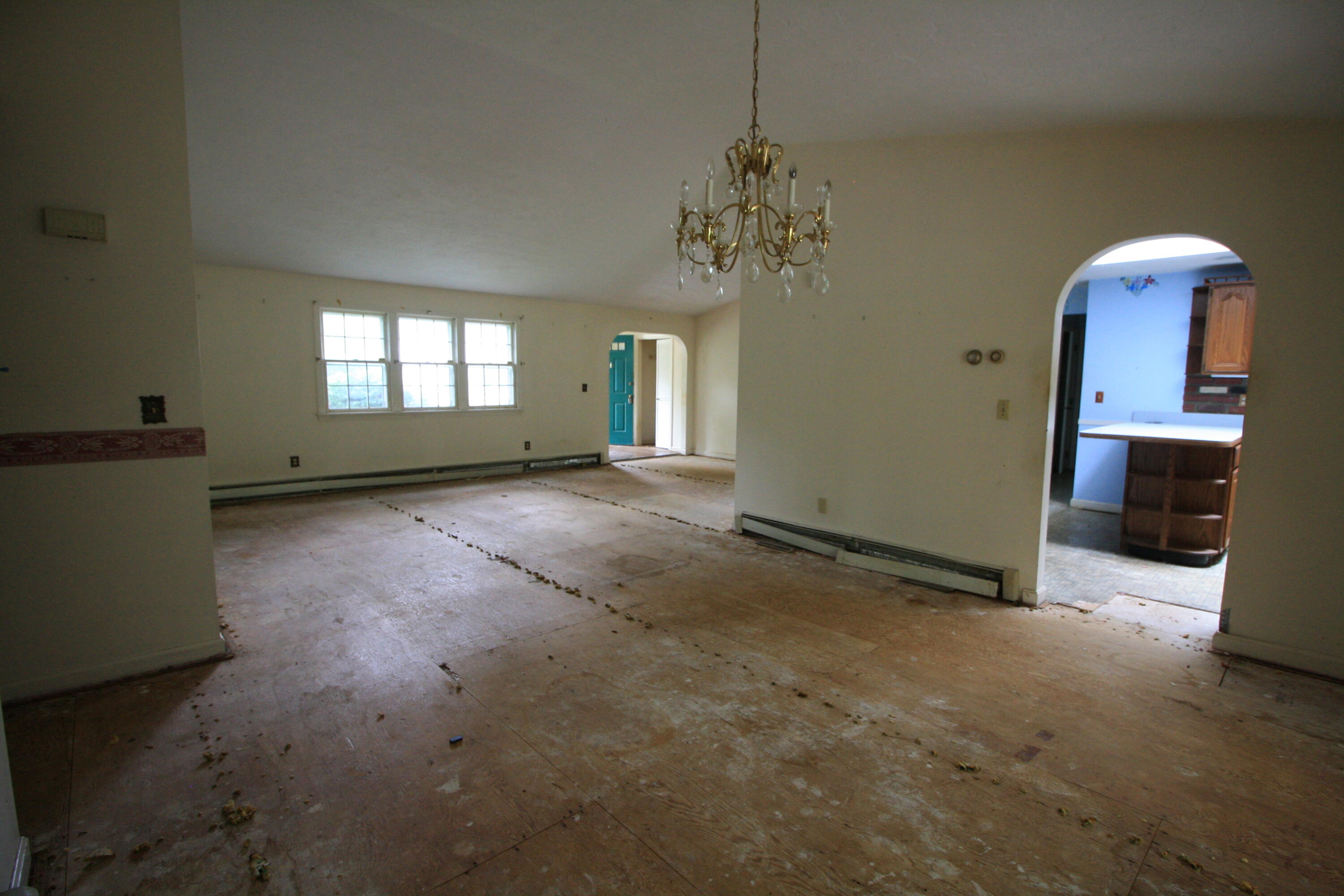 177 Thistle Drive Centerville, MA 02632 - Photo 8 of 22 an empty room with windows chandelier and view of a livingroom