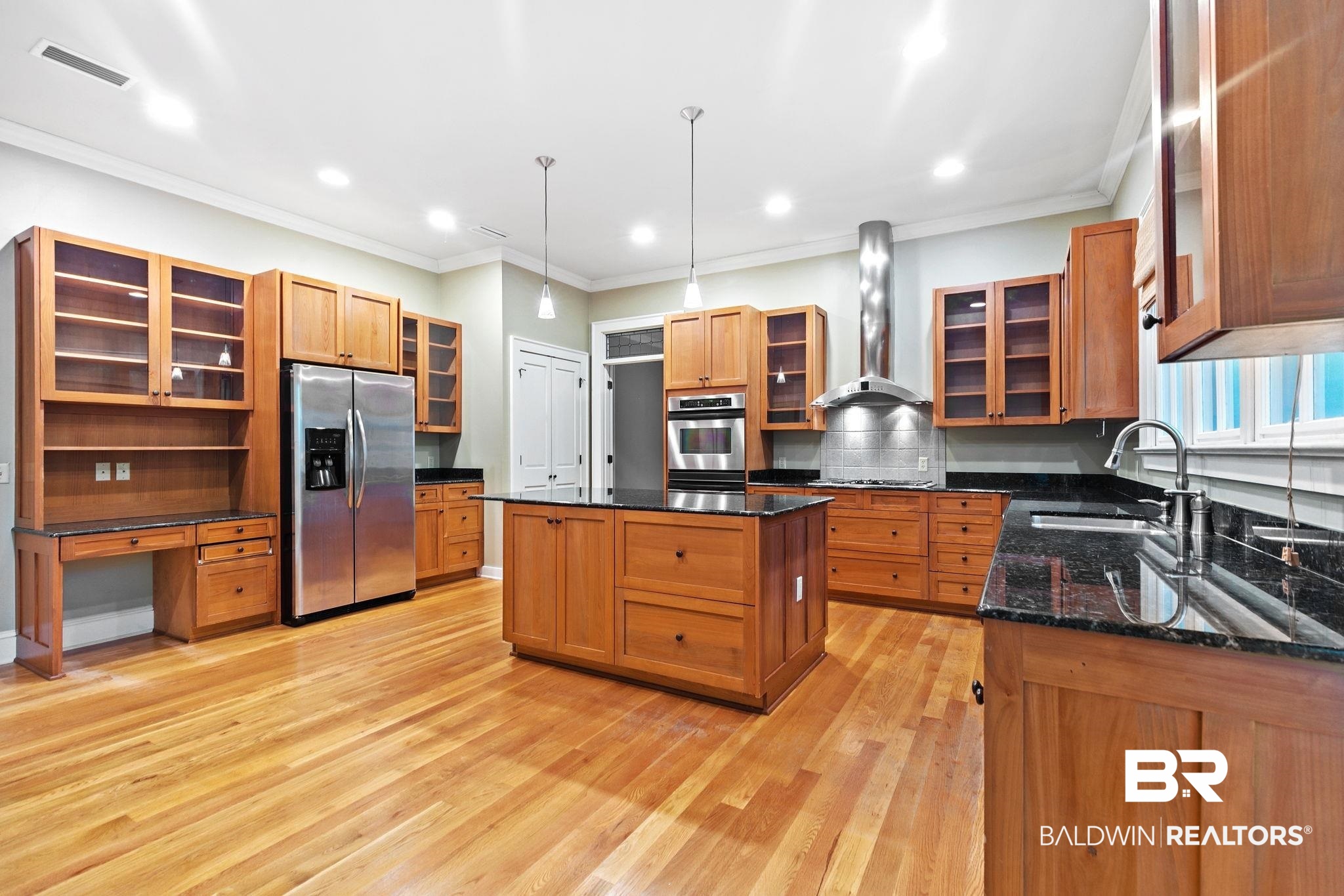 202 Beall Lane Daphne, AL 36526 - Photo 15 of 46 Kitchen with a center island, light hardwood / wood-style flooring, appliances with stainless steel finishes, and wall chimney range hood