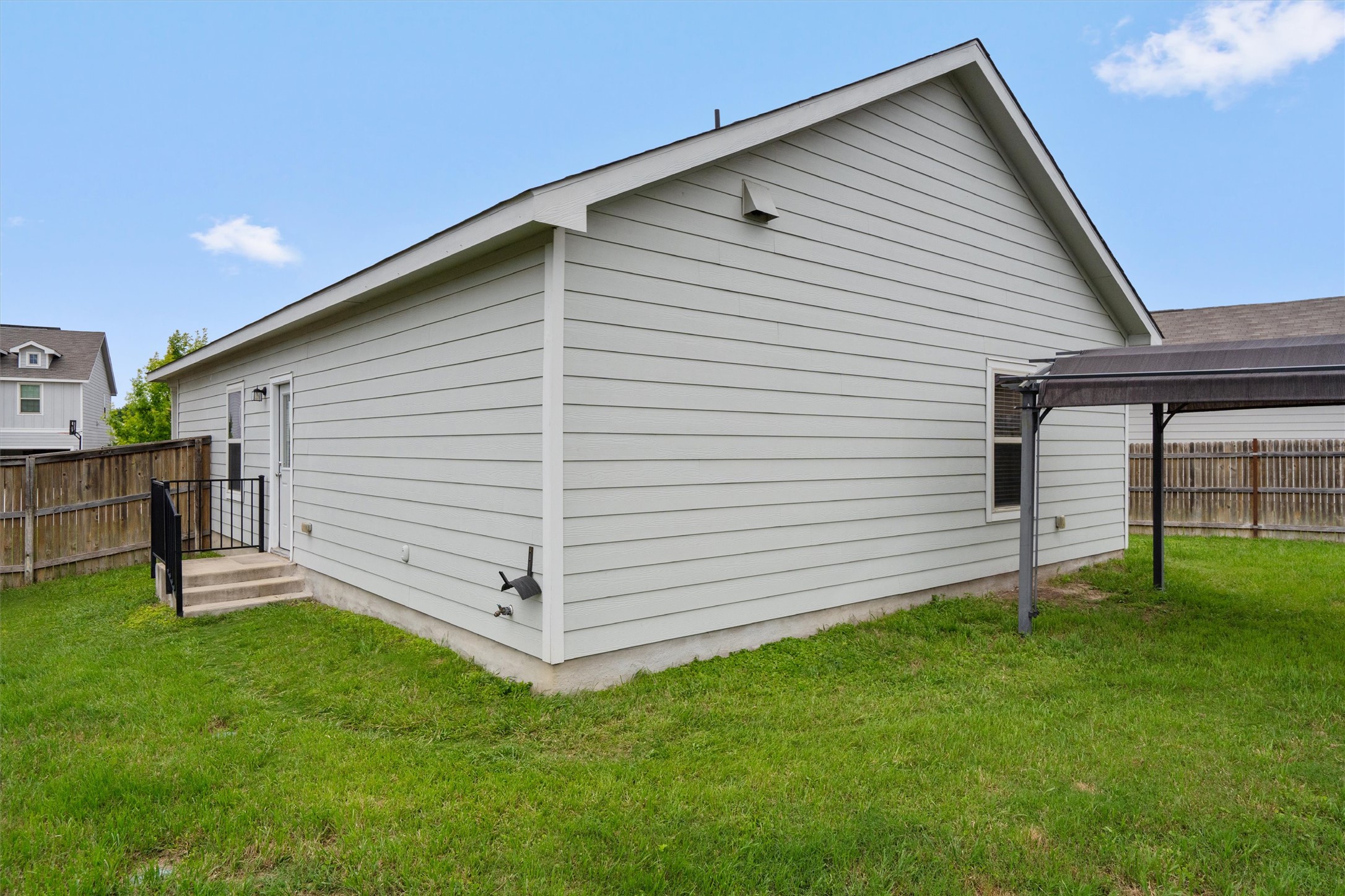 791 Circle Way Jarrell, TX 76537 - Photo 31 of 36 Rear exterior featuring horizontal siding, a gabled roofline, and a privacy fence