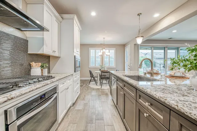 a large kitchen with stainless steel appliances granite countertop a stove a sink and a granite counter tops