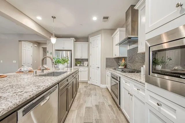 a large kitchen with granite countertop a sink and stove