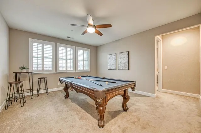 a room with furniture pool table and windows