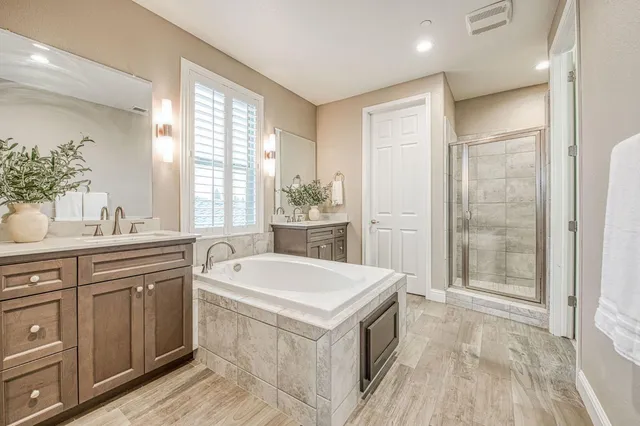 a large white kitchen with a large window a sink and cabinets