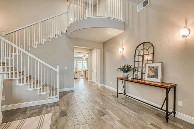 a view of a hallway with wooden floor and staircase