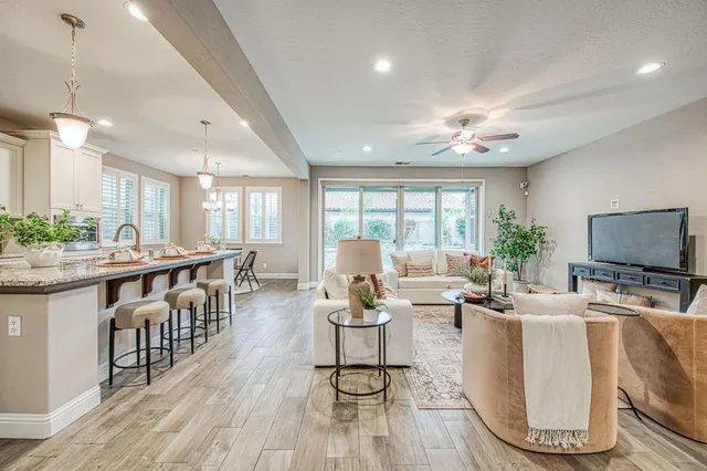 a living room with furniture a flat screen tv and a large window